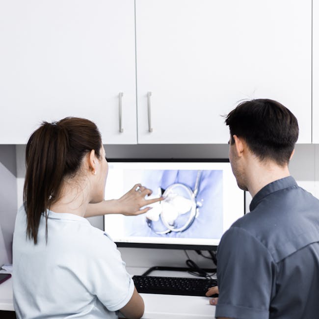 Two dentists analyzing dental x-rays on a computer screen in a modern clinic.